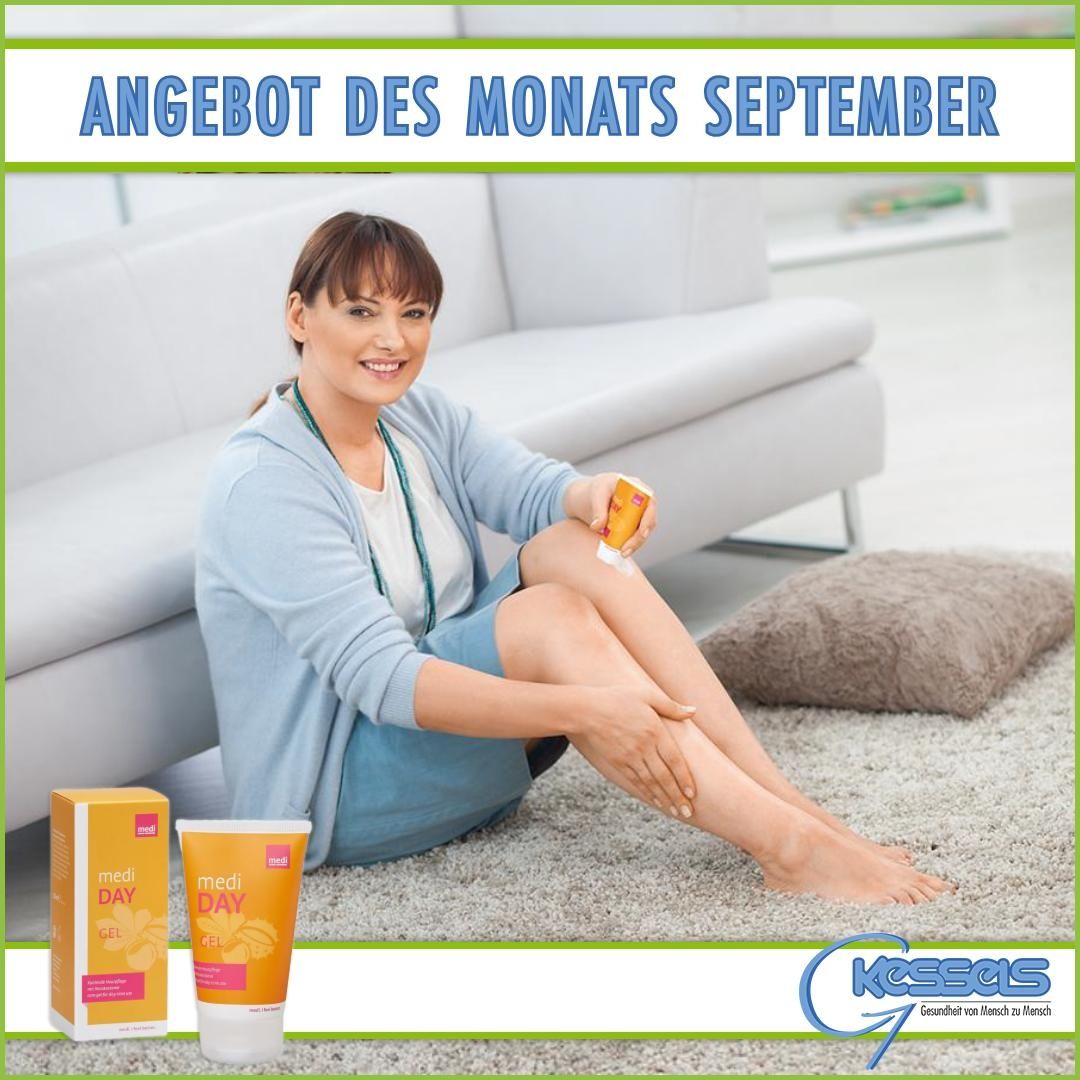 Eine Person trägt ein Hautpflegeprodukt auf ihr Bein auf, während sie auf einem weichen Teppich in einem modernen Wohnzimmer sitzt. In der Nähe sind Produkte ausgestellt.