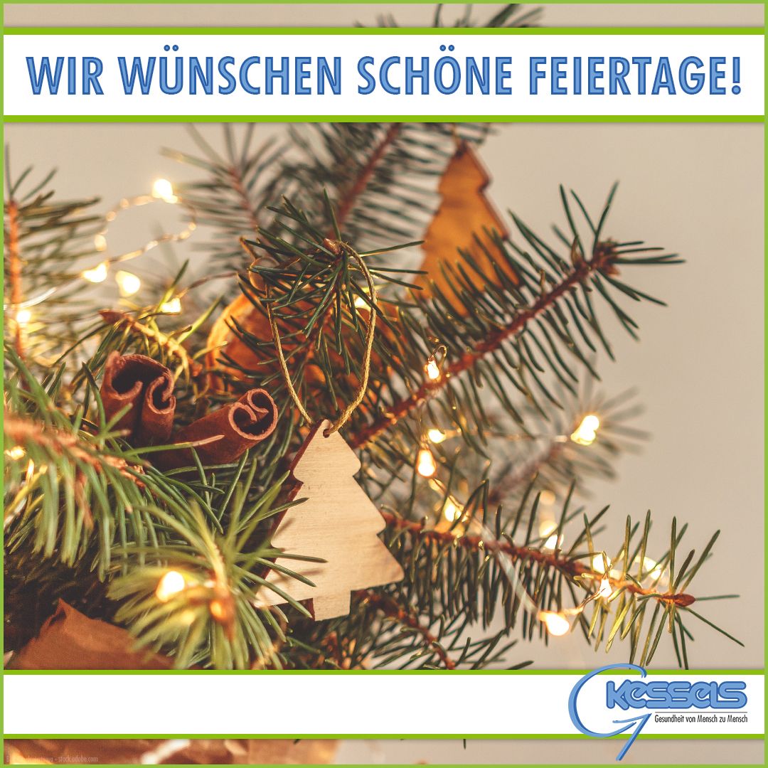 Ein festliches Arrangement aus Tannenzweigen mit Holzornamenten, funkelnden Lichtern und einem Gruß mit frohen Feiertagen auf Deutsch.