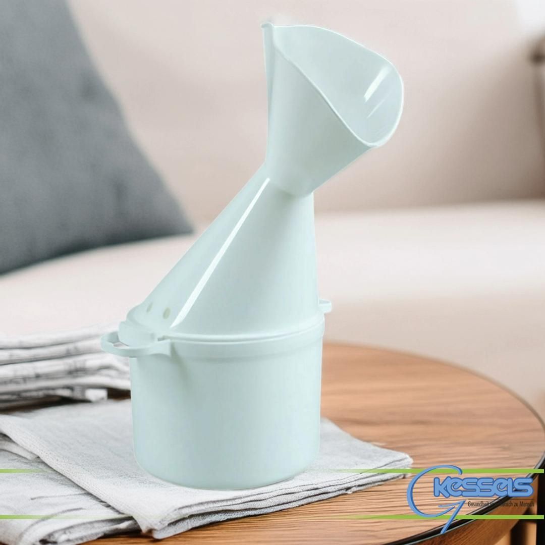 Hellblauer Trichter, der an einem Behälter befestigt ist und auf einem Holztisch mit einem Stapel Servietten und einem gemütlichen Sofa ruht, das im Hintergrund unscharf ist.